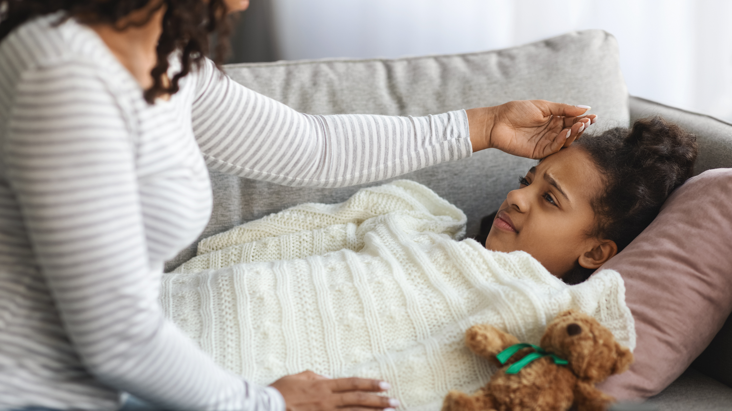 Worried,African,American,Mother,Checking,Her,Sick,Laying,On,Sofa
